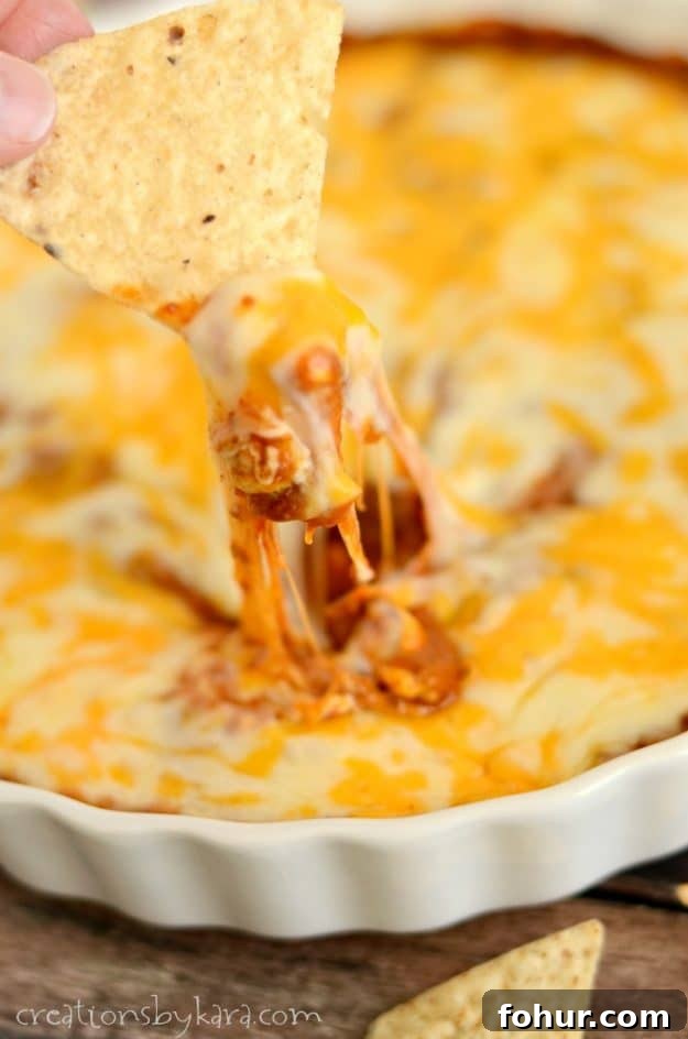 Easy Chili Cheese Dip - loaded with beans, cream cheese, and two kinds of cheeses, this dip is always a hit! chili dip with strings of melted cheese