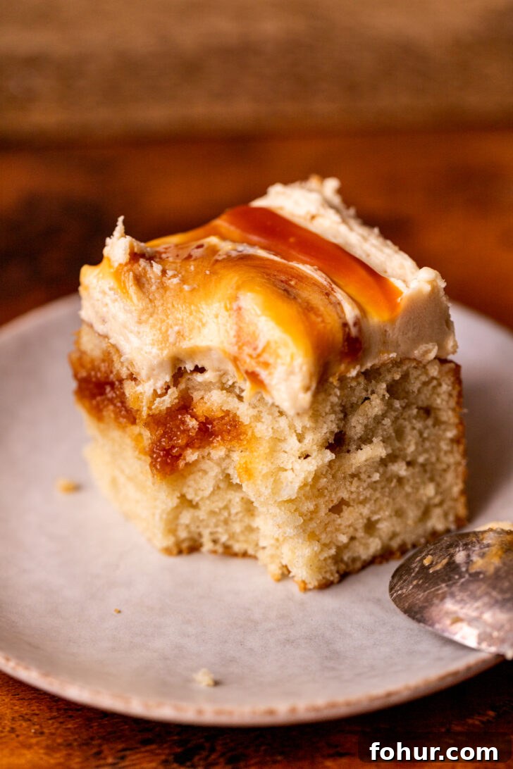 Brown Butter Caramel Cake with Salted Caramel Glaze 8 Bite missing from a cake on a plate.