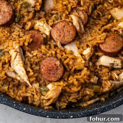 Cajun style chicken and sausage jambalaya in a large black pot.