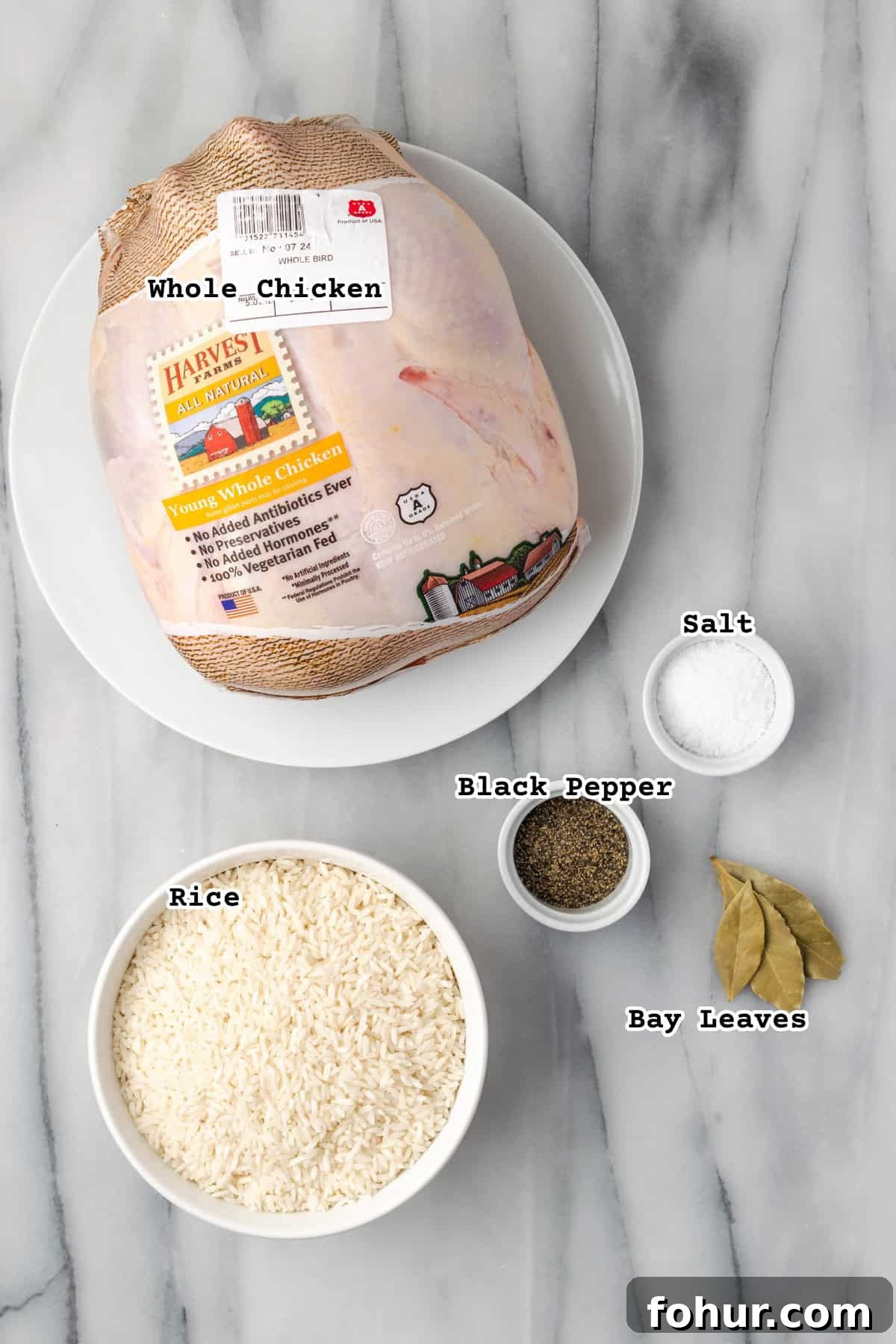 Ingredients for one pot chicken and rice sitting on a marble counter.