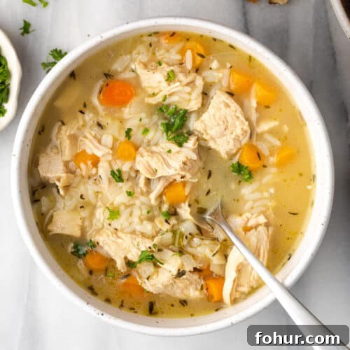 Old fashioned chicken and rice soup served in a white bowl.