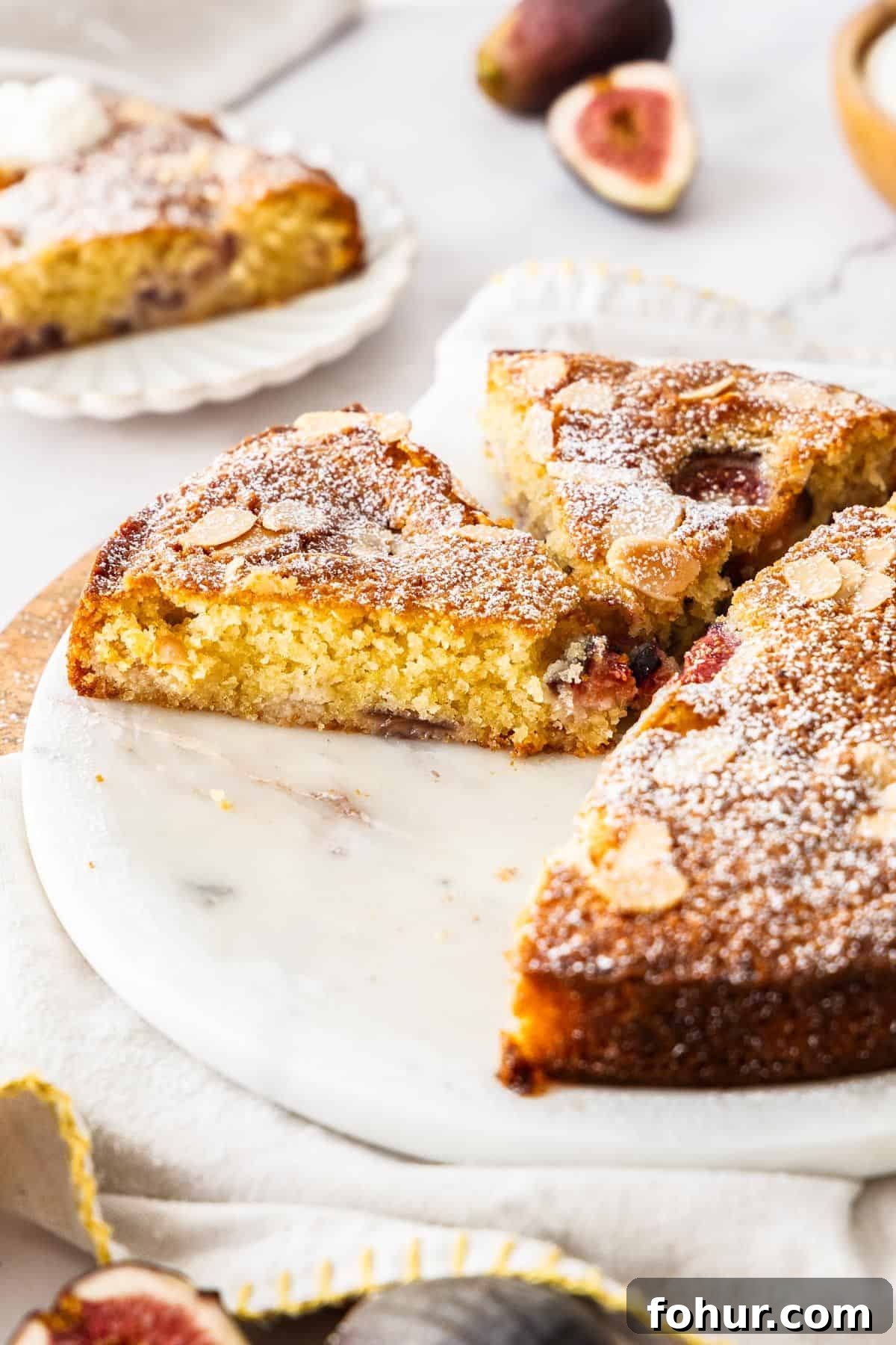 Gluten-Free Fig Cake on a white platter, with some slices removed.