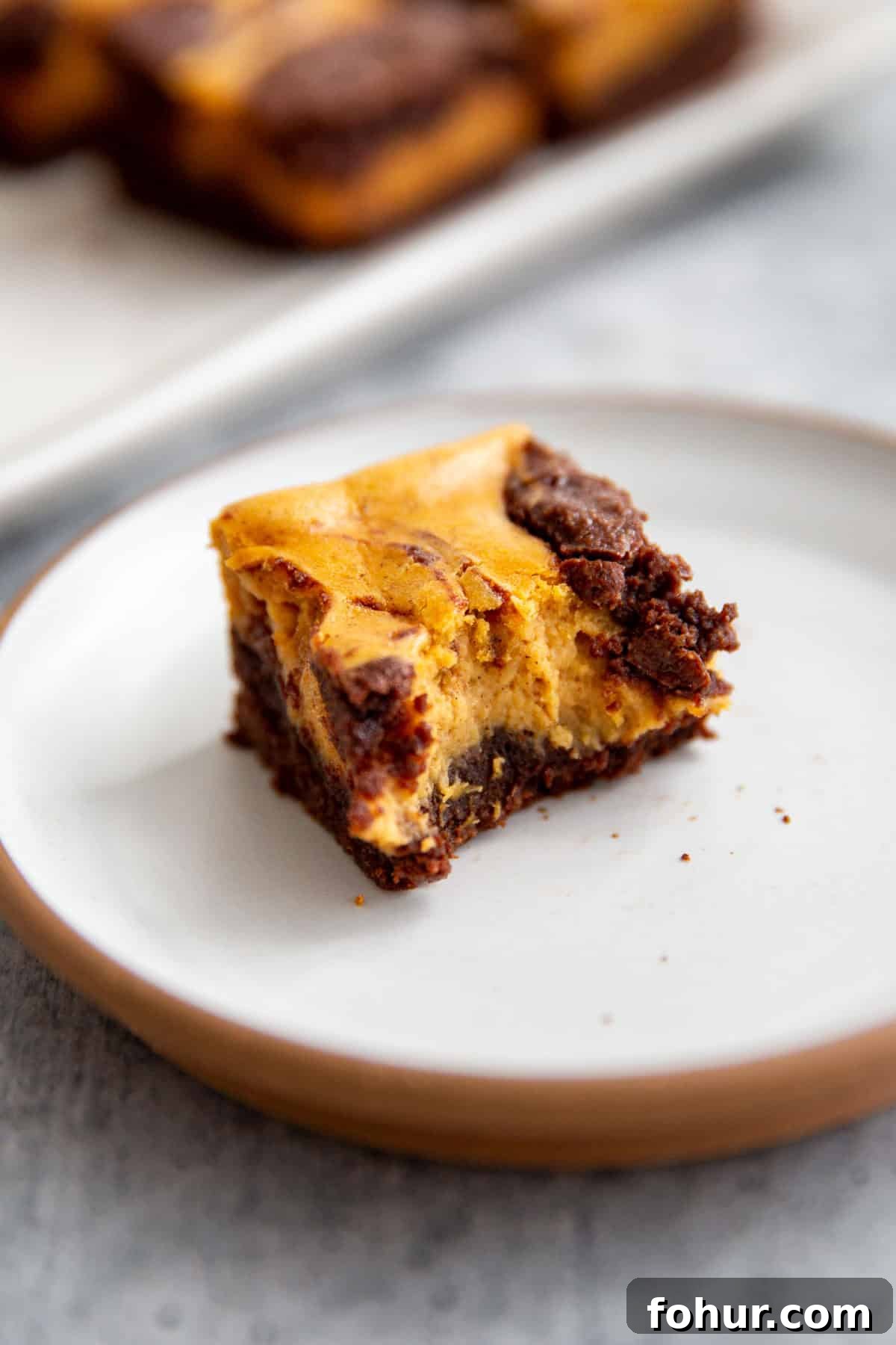 Fudgy Pumpkin Cheesecake Swirl Brownies Recipe 11 a bite taken out of fudgy pumpkin brownies swirled with cheesecake