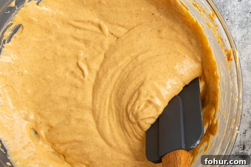 Fudgy Pumpkin Cheesecake Swirl Brownies Recipe 5 cheesecake batter in a glass bowl with a spatula