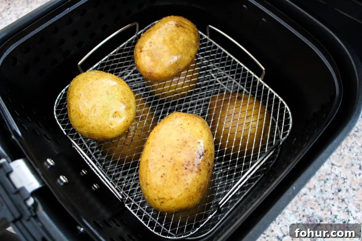 Creamy Garlic Mashed Potatoes Made in an Air Fryer 4 2 layers of prepared potatoes on a rack in a basket style air fryer.