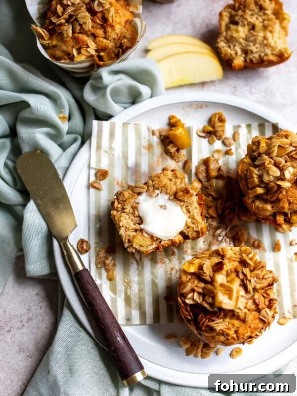3-Ingredient Pumpkin Muffins Recipe 8 Apple spice muffins on a plate with a butter knife and a pat of butter on one muffin.