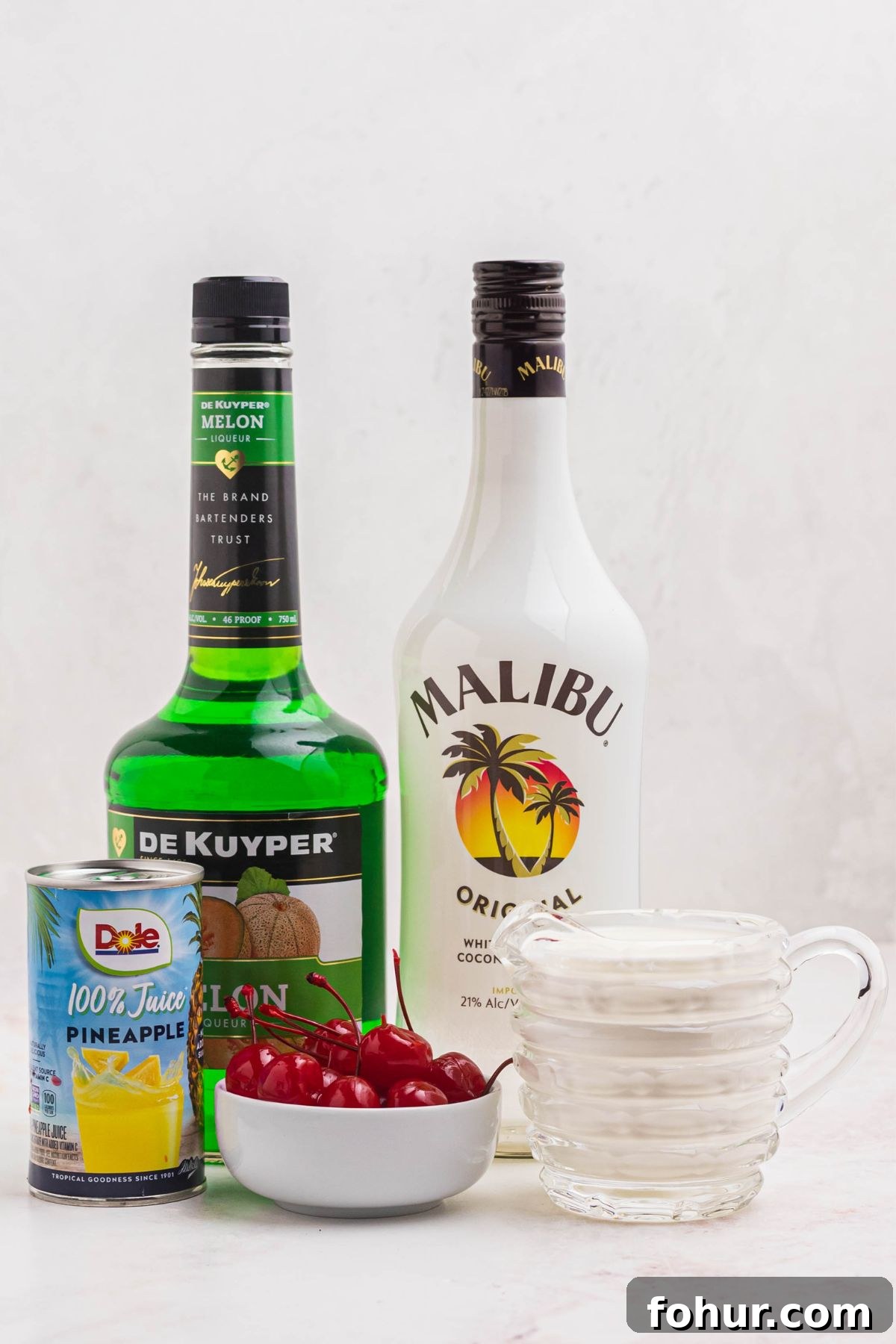 Scooby Snack Shot Cocktail Recipe 3 Ingredients needed to make scooby snack shots on a marble table.