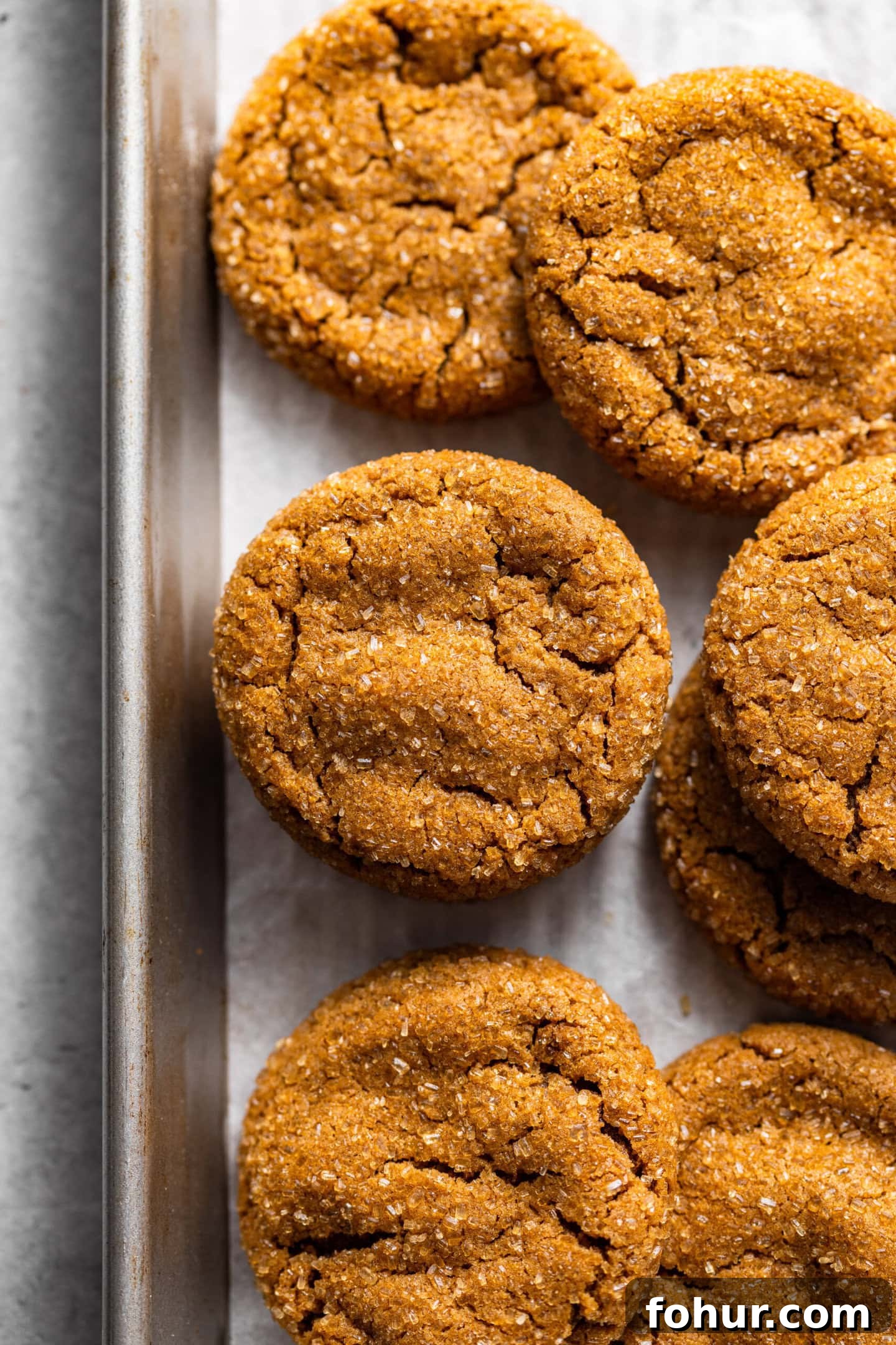 Soft, Chewy Small-Batch Molasses Cookies 2 Fresh baked molasses cookies on top of a baking sheet.