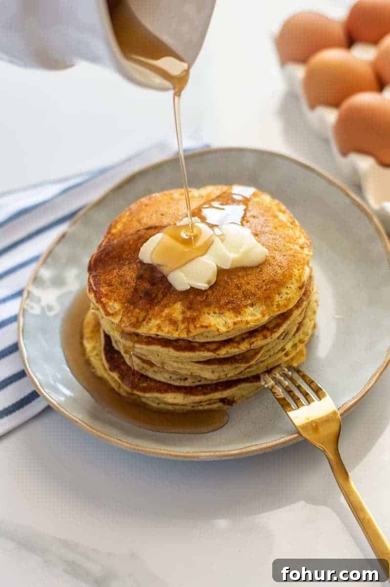 Maple syrup being poured on pancakes