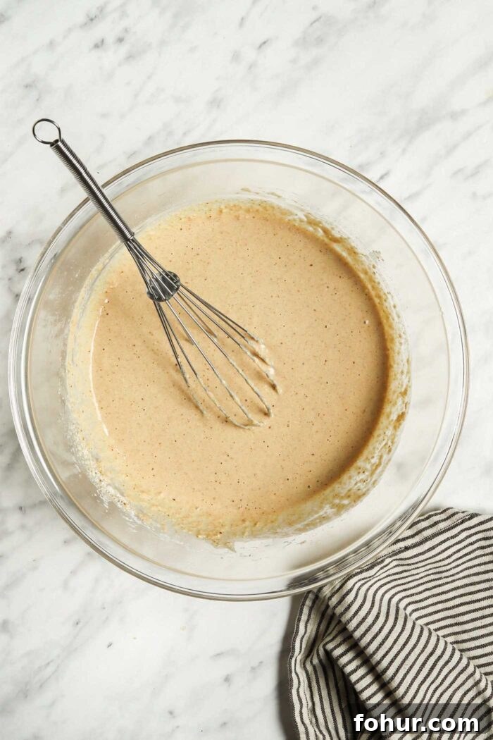 Fluffy Vegan Oat Flour Pancakes (Banana-Free) 3 Banana oat pancake batter in a glass mixing bowl.