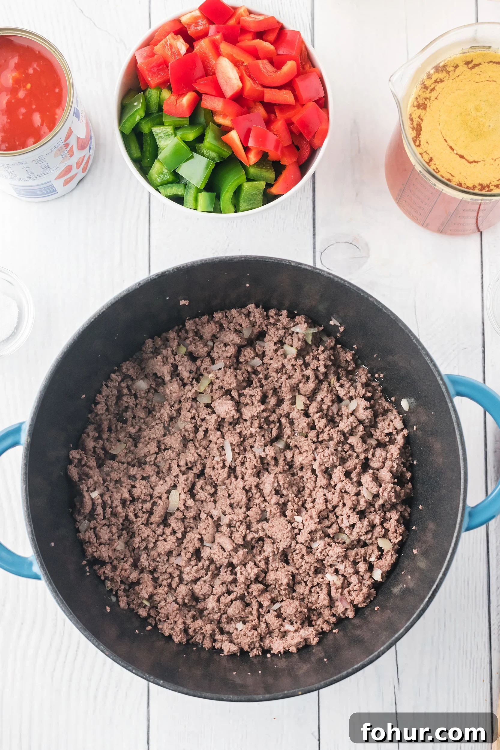 Stuffed Pepper Soup Recipe That Warms the Soul 3 sautéed ground beef, onions and garlic in a Dutch oven on a white board