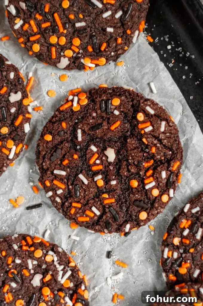 Spooky Gluten-Free Halloween Cookies with Dairy-Free Option 5 Dark black chocolate cookies covered in halloween inspired sprinkles.