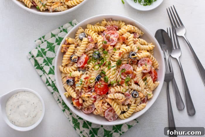 Creamy Bacon Ranch Pasta Salad with Peas and Cheddar 4 White bowl of bacon ranch pasta salad set on a green and white napkin.