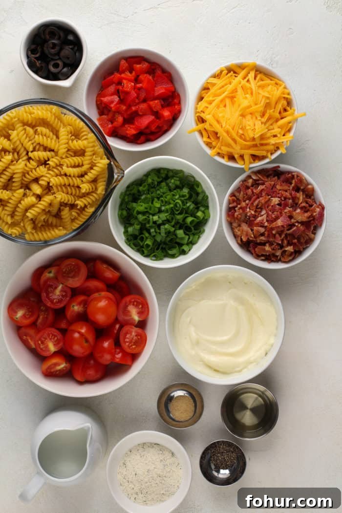 Creamy Bacon Ranch Pasta Salad with Peas and Cheddar 5 Ingredients for bacon ranch pasta salad arranged on a white countertop.