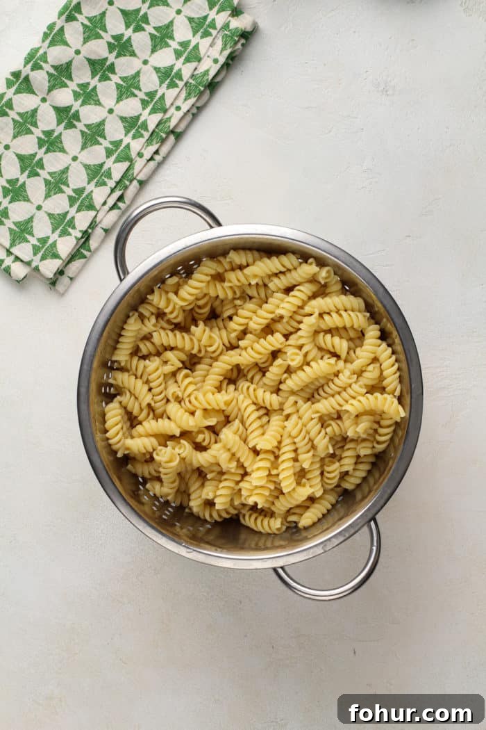 Creamy Bacon Ranch Pasta Salad with Peas and Cheddar 6 Cooked and drained rotini pasta in a colander for pasta salad.