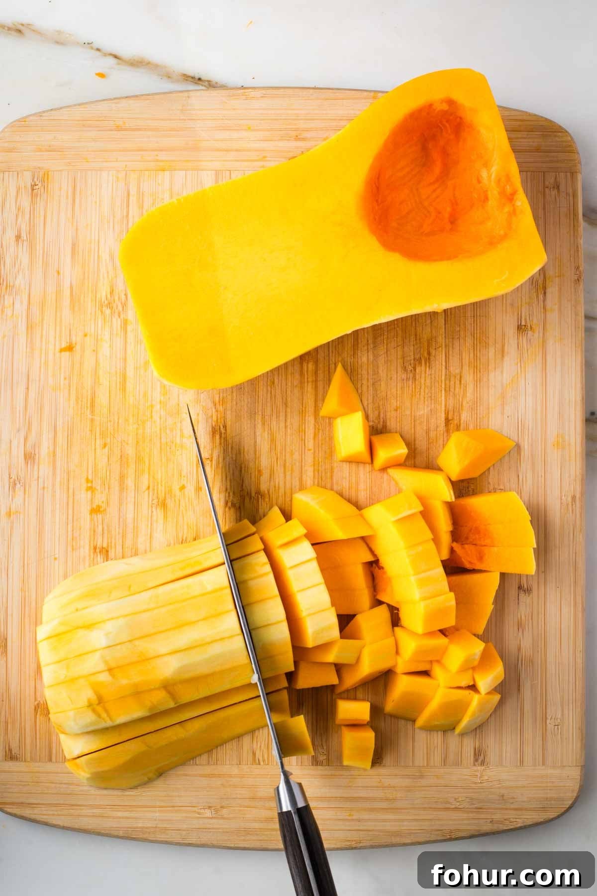 Vegan Fall Minestrone Soup with Roasted Autumn Vegetables 5 Cutting peeled butternut squash into small dice.