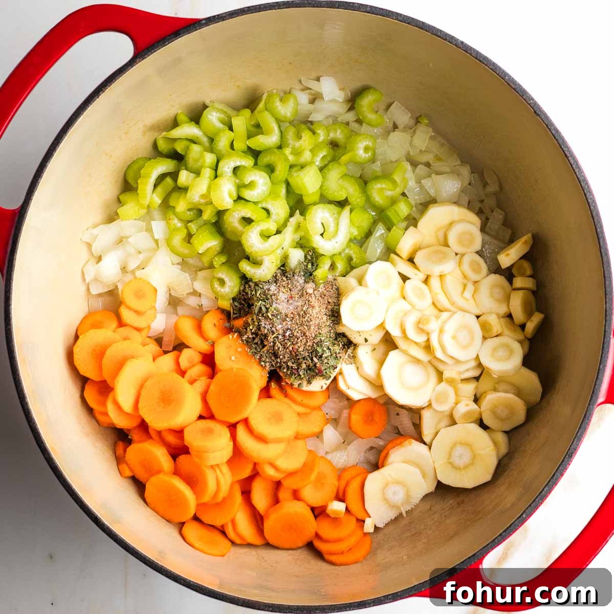 Vegan Fall Minestrone Soup with Roasted Autumn Vegetables 6 Dutch oven with carrots, parsnips, spices and celery on top of sauteed onions.