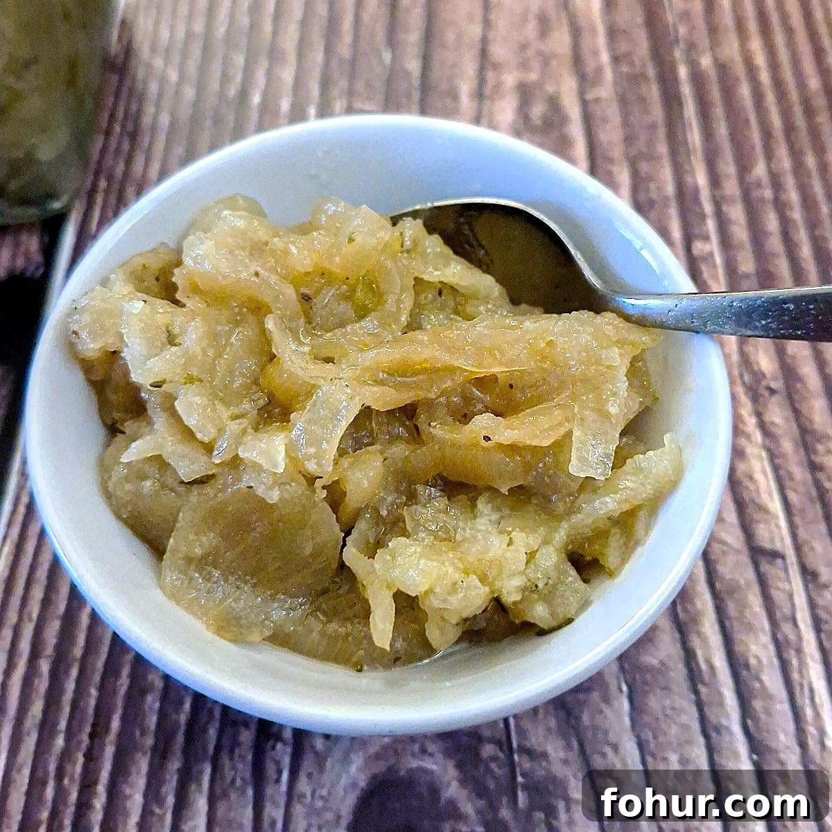 Caramelized Onion and Apple Marmalade Recipe 5 A small white dish of onion and apple marmalade with a spoon
