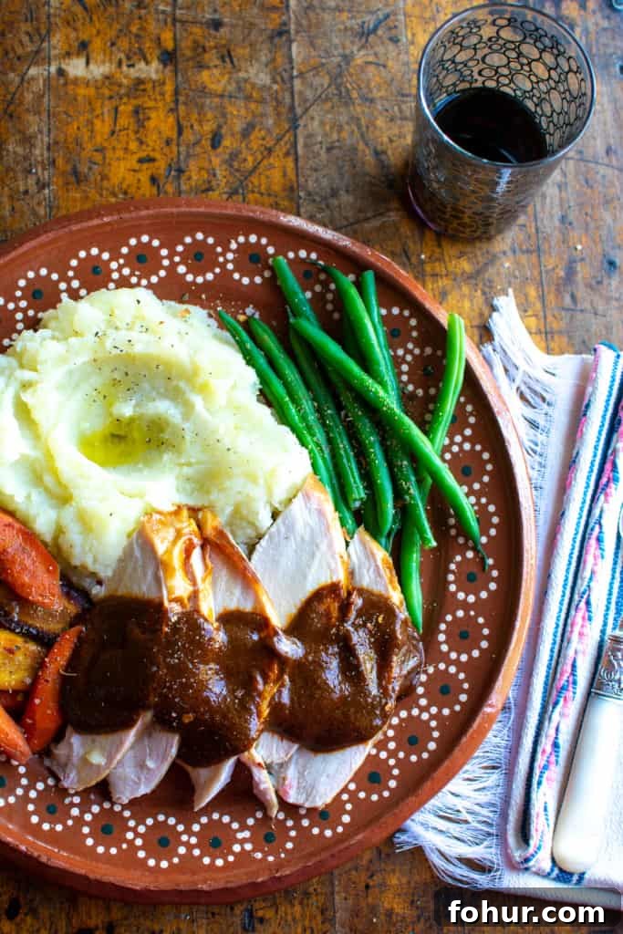 Sliced Mexican turkey plated with mashed potatoes and vegetables