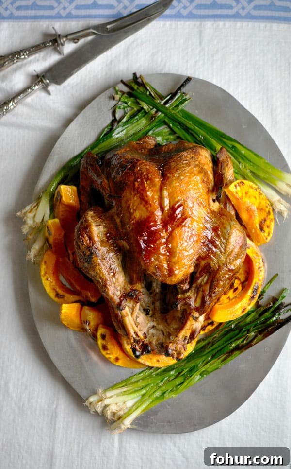 Mexican Lime-Poached Turkey on a silver platter with roasted butternut squash and charred scallions
