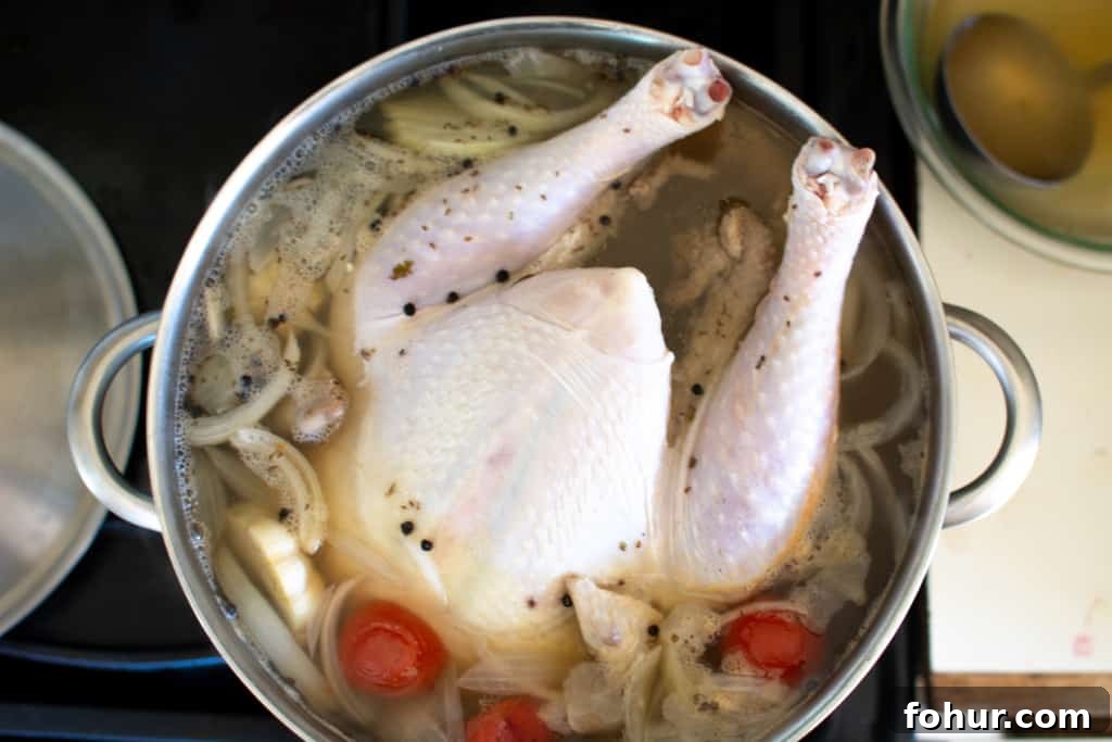 Turkey in a large pot of poaching liquid on the stove