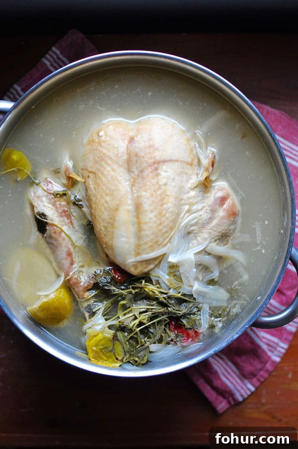 Turkey resting in poaching liquid in the stock pot