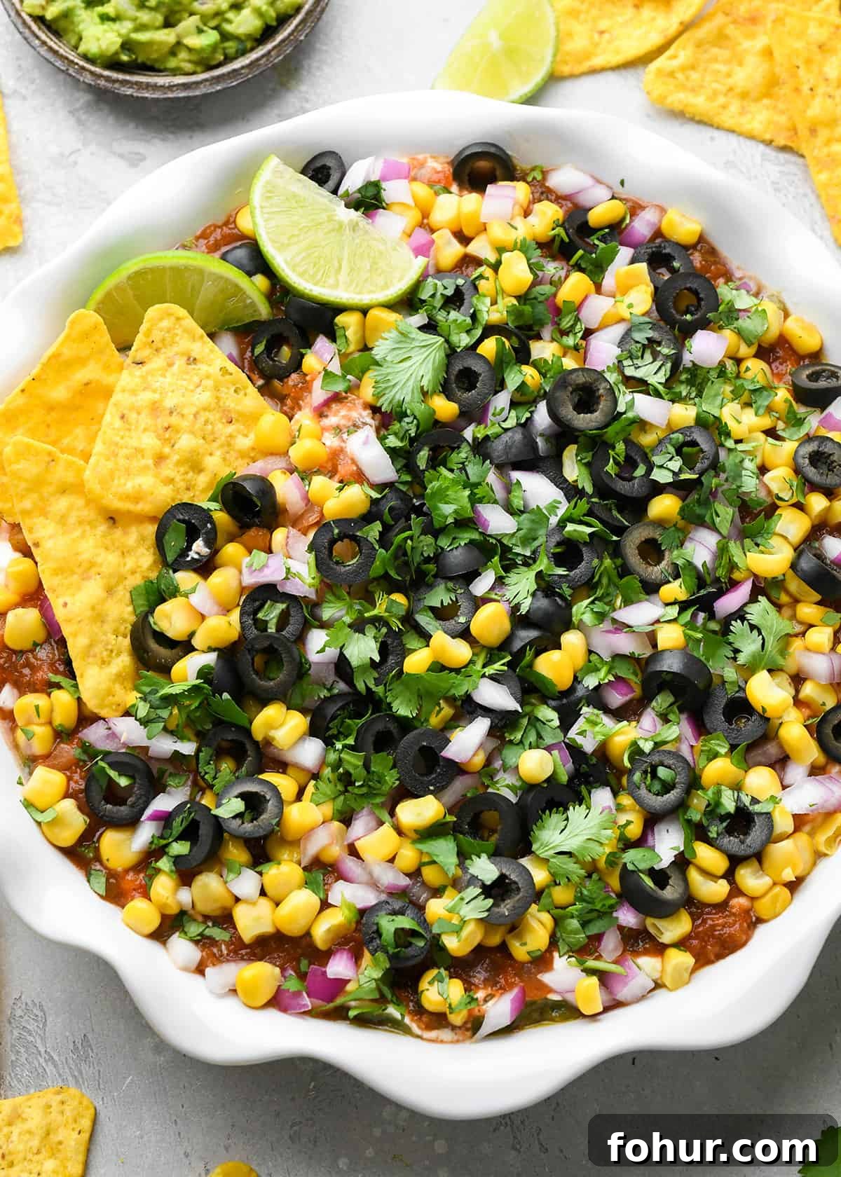 Authentic Mexican Seven Layer Dip Recipe 10 Mexican 7 Layer Dip in a pie dish with chips