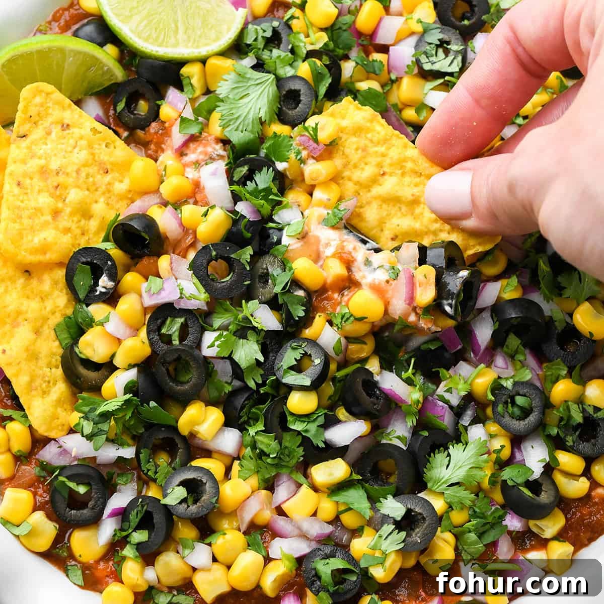 Authentic Mexican Seven Layer Dip Recipe 11 a chip dipping into Mexican 7 Layer Dip