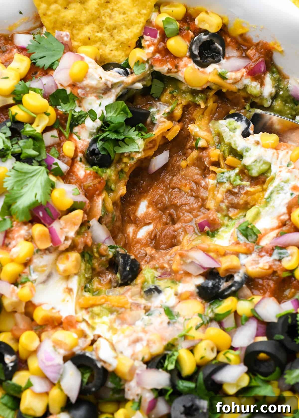 Authentic Mexican Seven Layer Dip Recipe 4 up close photo of Mexican 7 Layer Dip in a serving dish