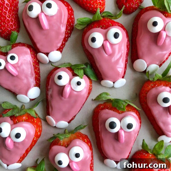 Strawberries coated with pink chocolate and decorated with candy eyes to resemble little owls.