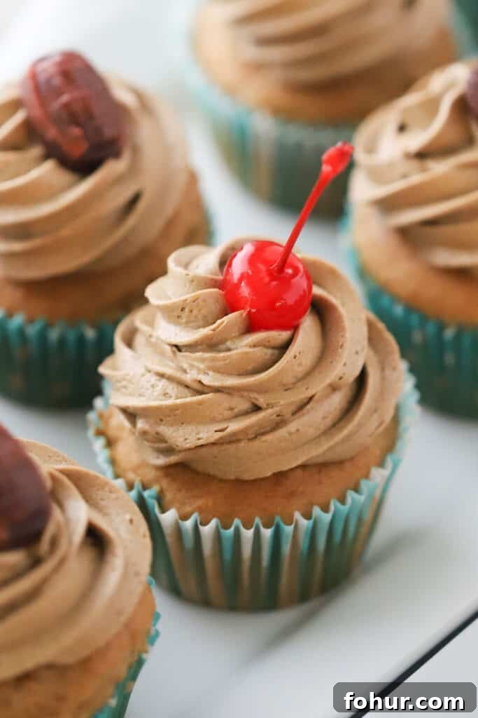 Root Beer Float Cupcakes with Vanilla Cream Frosting 2 Root beer float cupcakes topped with root beer buttercream frosting and maraschino cherries.