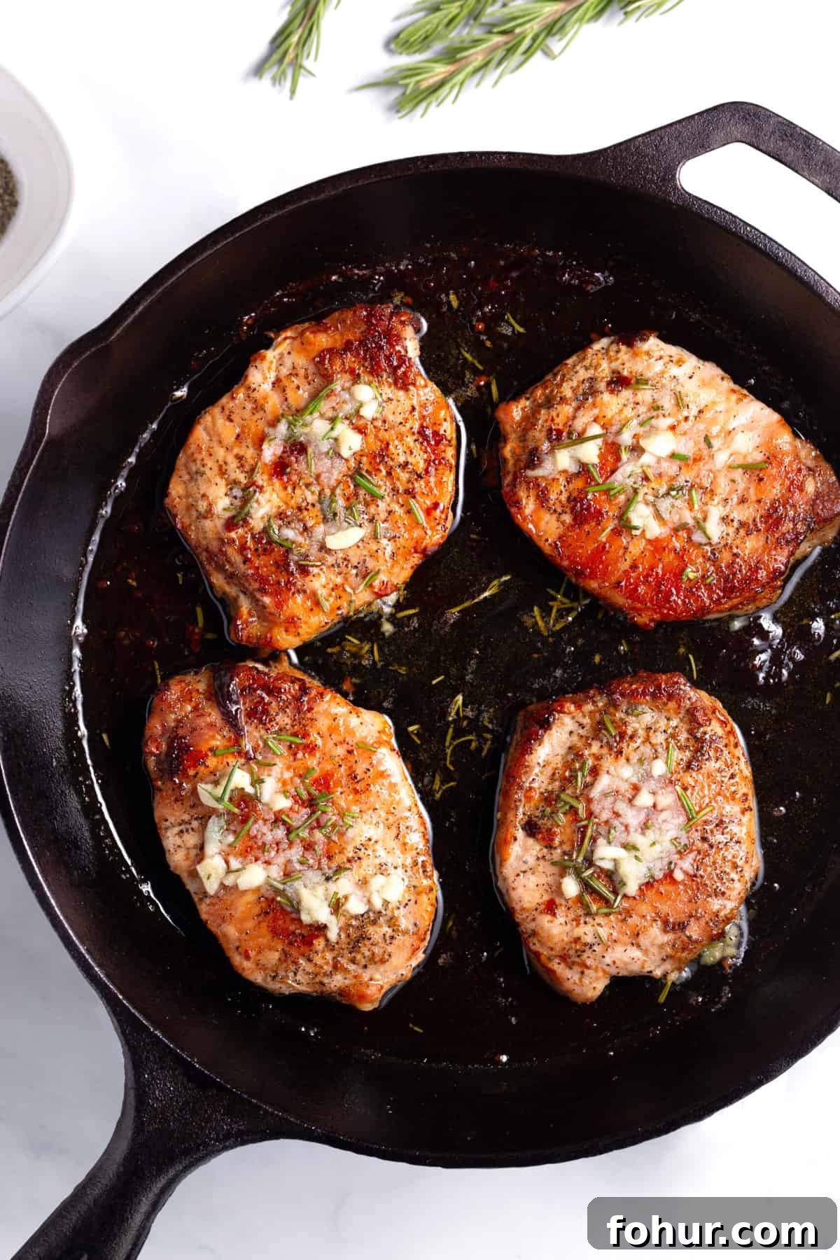 baked pork chops served in a cast iron skillet