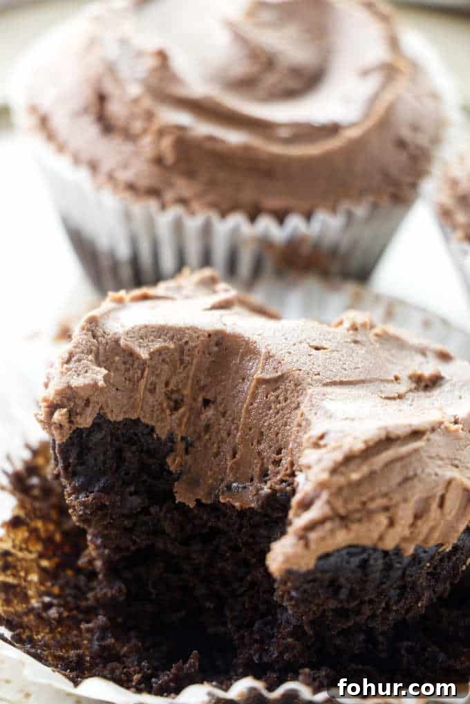 A partially eaten chocolate cupcake.