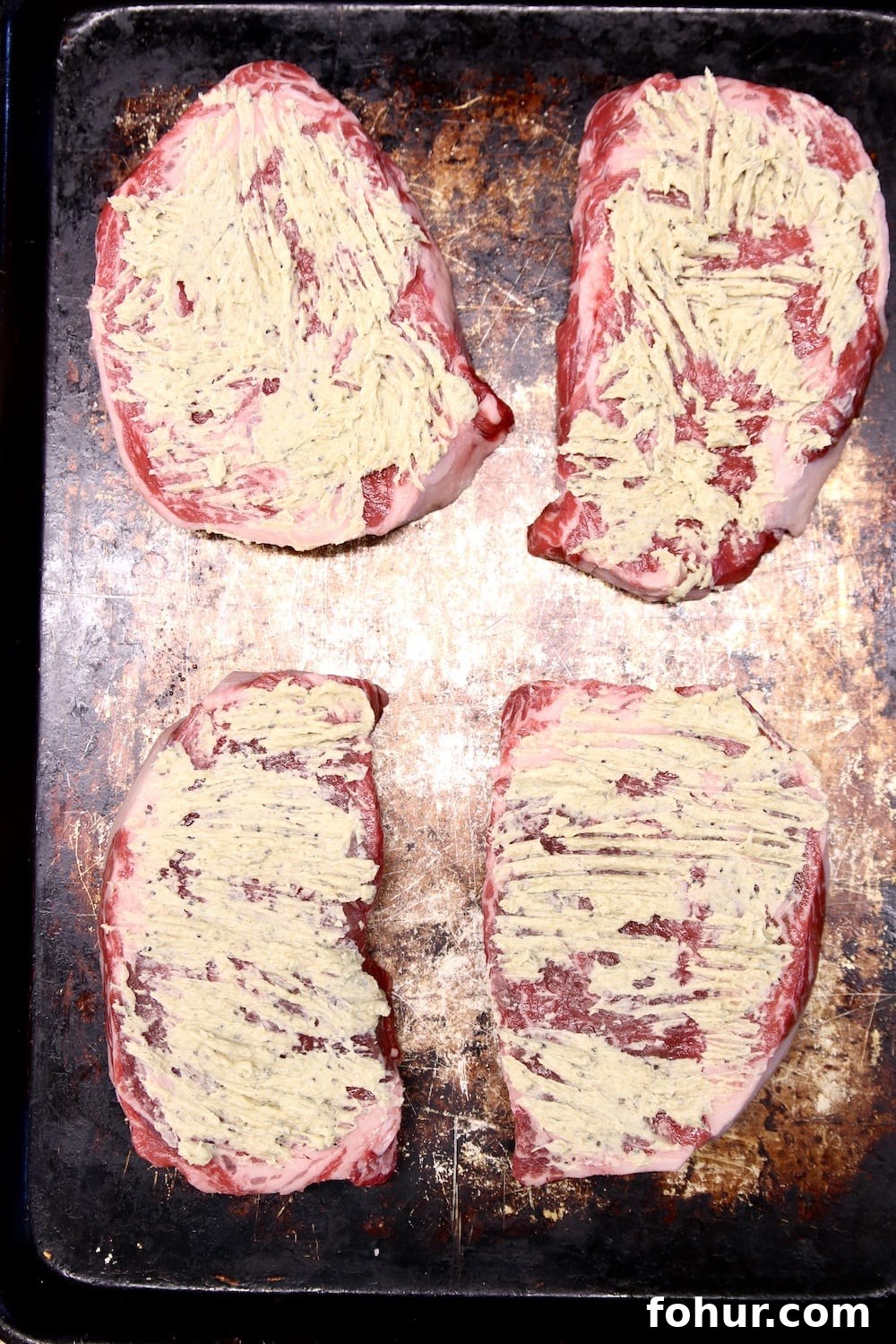 ribeye steaks with butter on a grill