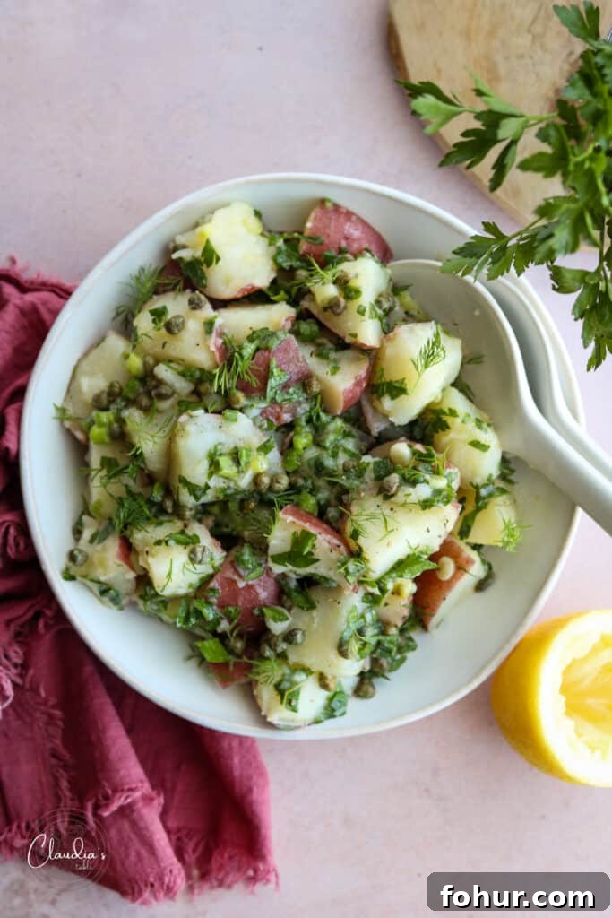Zesty Lemon Caper Potato Salad with Fresh Herbs 2 Lemon caper potato salad in white bowl with red napkin