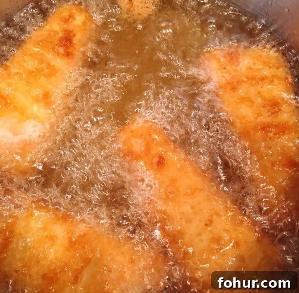 Crispy Fried Fish Sandwich Recipe with Tartar Sauce 3 Fish Fillets frying in oil
