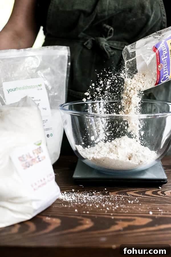 How to Bake with Gluten-Free Flours: Tips and Techniques 5 baker weighing flour in a glass mixing bowl