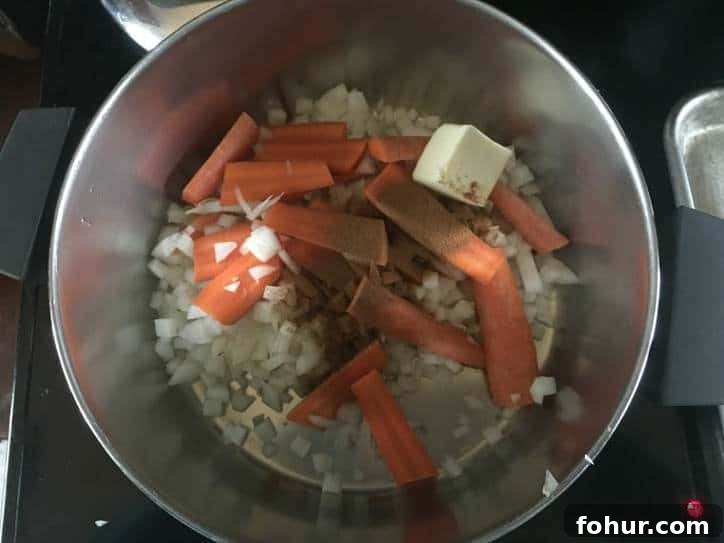 How to Make Homemade Chicken Stock from Scratch 3 onions, carrots and a pat of butter in a stock pot on the stovetop