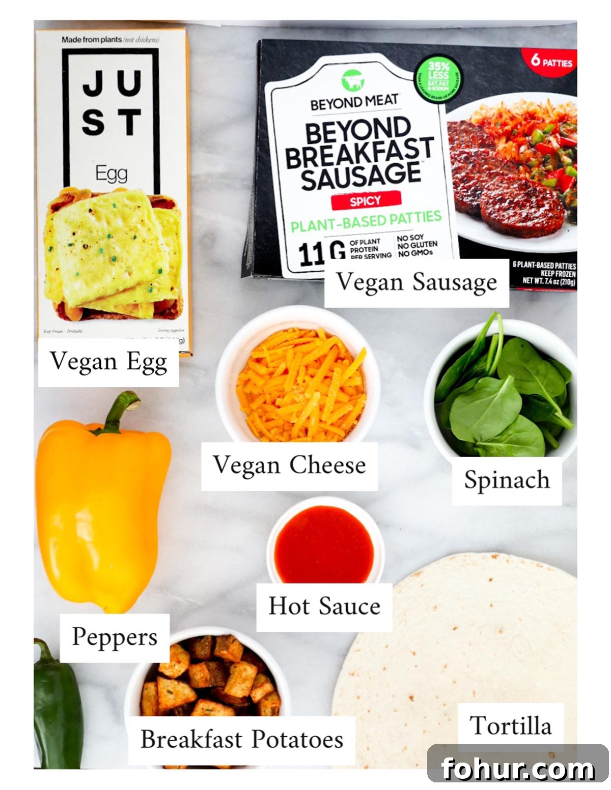 Vegan Breakfast Burrito Recipe with Tofu, Beans and Avocado 3 Labeled ingredients including: Just egg, vegan breakfast sausage, peppers, vegan cheese, spinach, hot sauce, tortillas, and breakfast potatoes