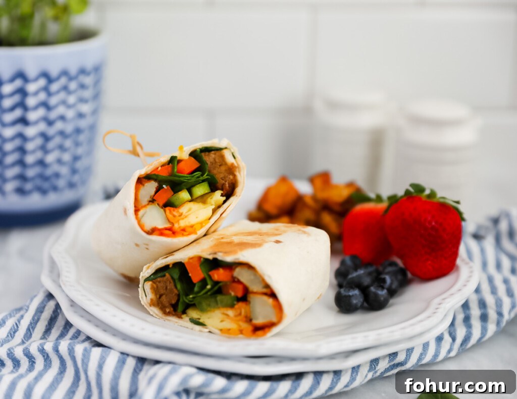 Vegan Breakfast Burrito Recipe with Tofu, Beans and Avocado 6 A burrito on a plate with blueberries, strawberries, and breakfast potatoes