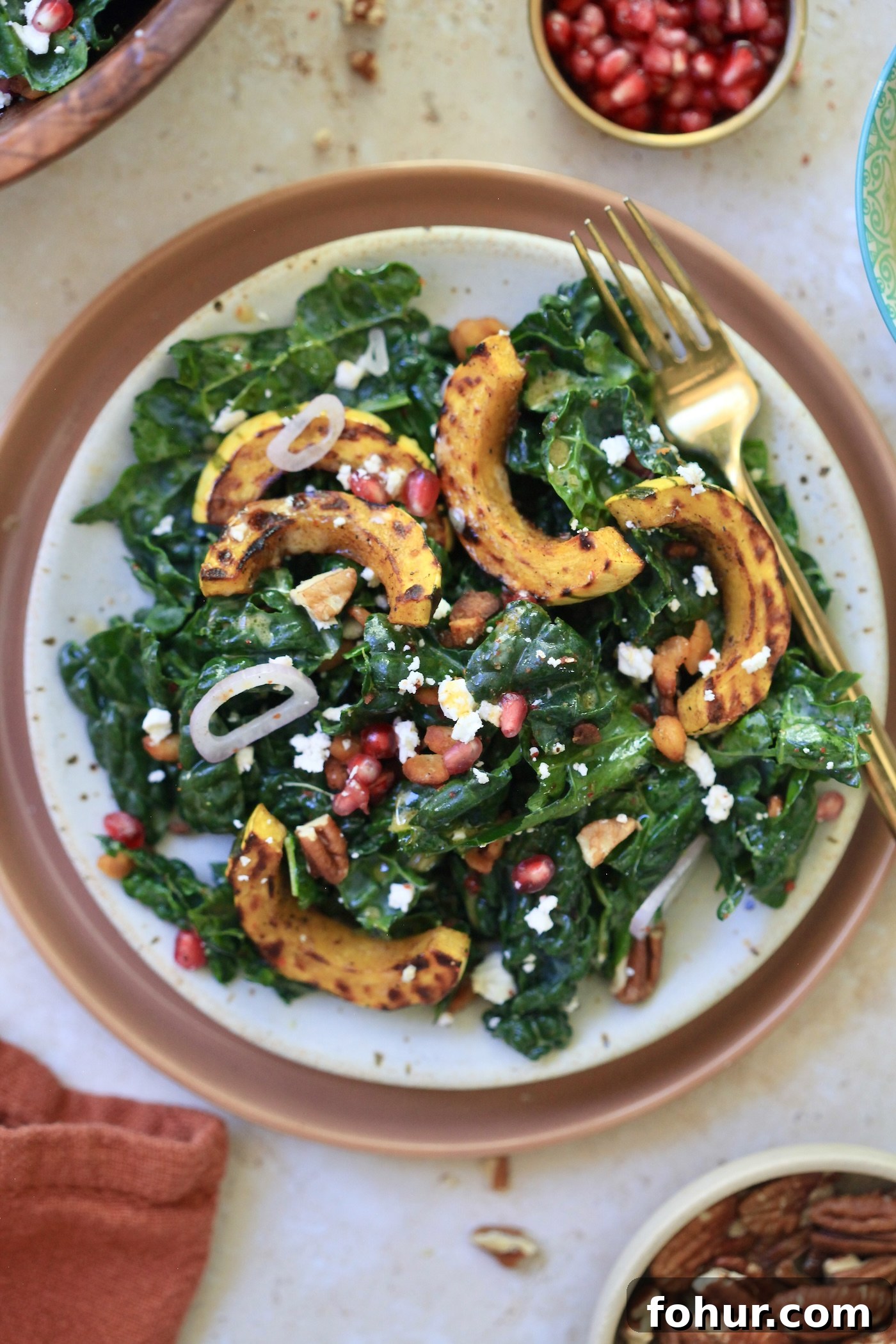 plate with kale squash salad and gold fork