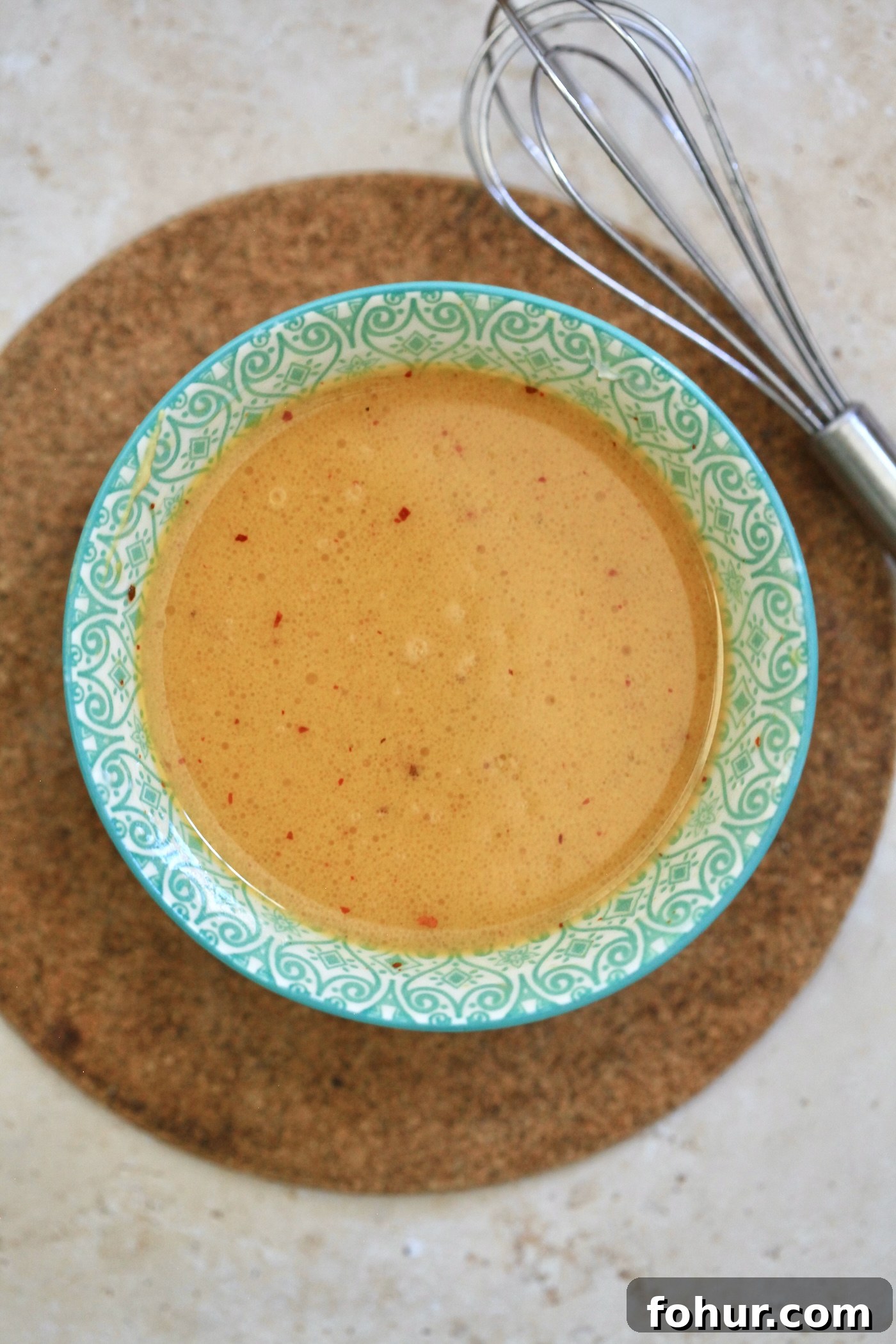 yellow dressing in blue bowl