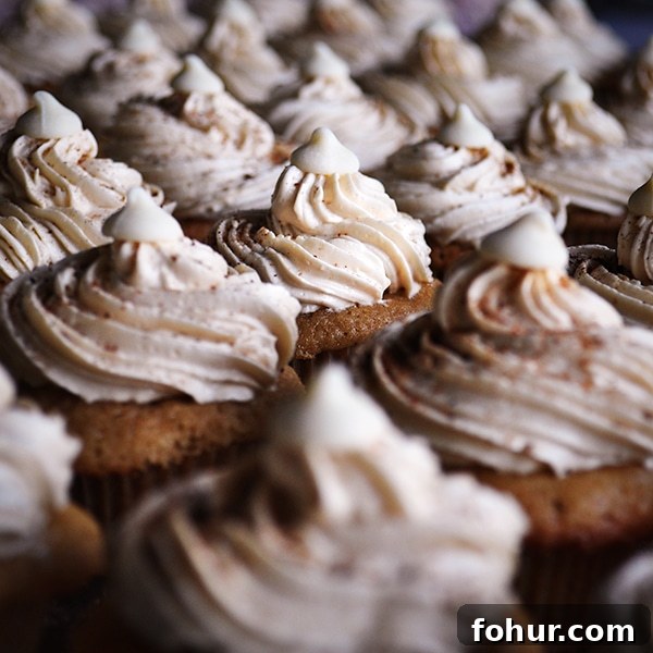 Mini Chai-Spiced Cupcakes with Italian Meringue Buttercream 3 A tray of mini chai latte cupcakes frosted with white chocolate and chai Italian meringue buttercream.