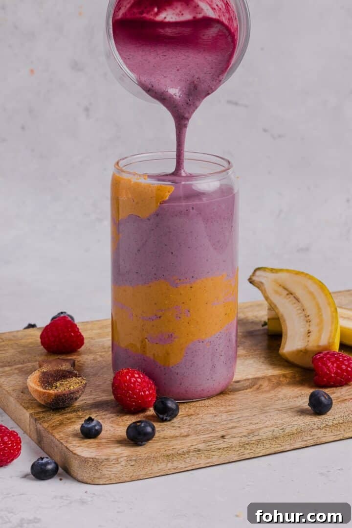 Creamy Peanut Butter and Mixed Berry Smoothie Recipe 4 Smoothie being poured into a tall glass