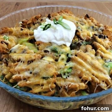 12 St. Patrick's Day Recipes to Make This Year 12 Waffle fries in a small pile in a bowl with spices and sour cream on top