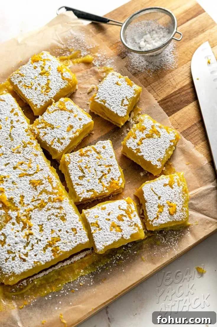 Fresh batch of vegan lemon bars being cut on a cutting board
