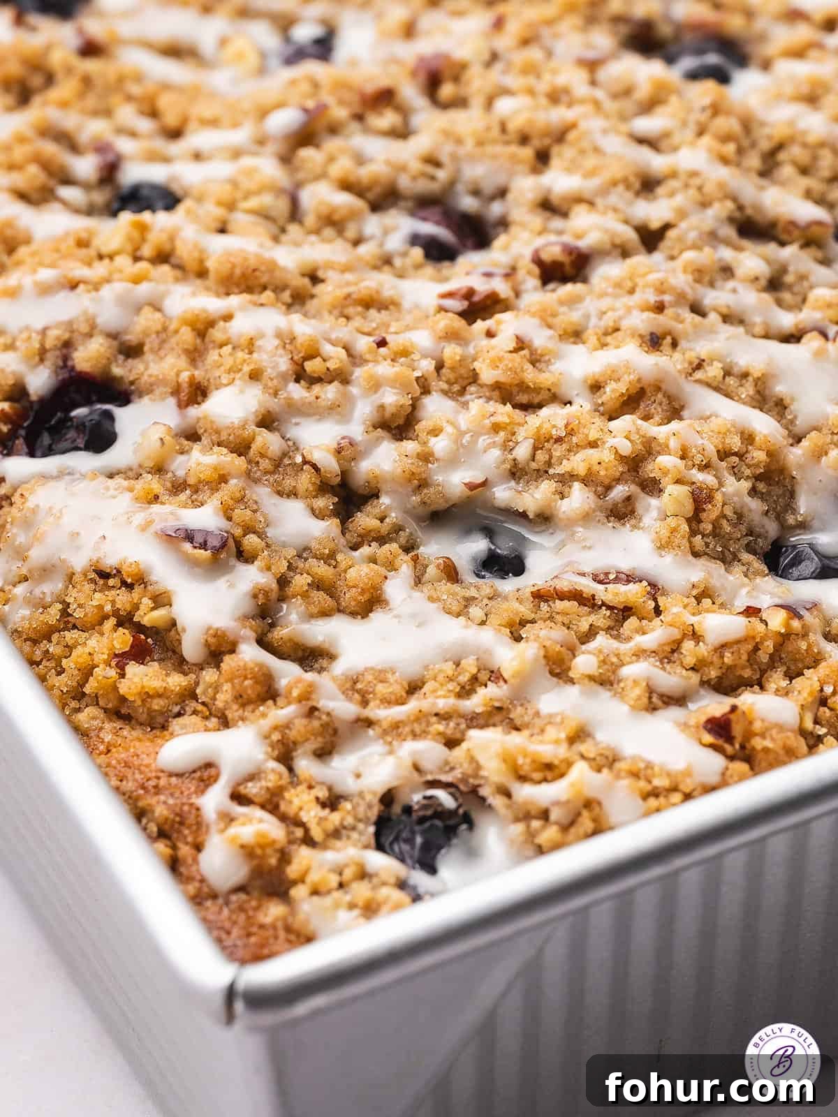 With fresh blueberries and sour cream, this Blueberry Coffee Cake is moist and tender, with an irresistible sweet & crunchy streusel topping. A baking pan of blueberry coffee cake