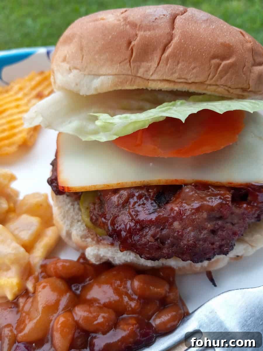 Amish-Style Grilled Burgers: Classic BBQ Recipe 8 grilled barbecued hamburger on a plate with baked beans potato salad and chips