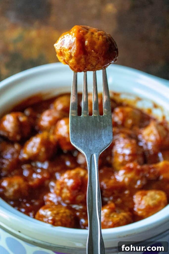 Slow Cooker Spicy Hawaiian Meatballs with Sweet Pineapple Glaze 6 Slow Cooker Spicy Hawaiian Meatballs on a fork
