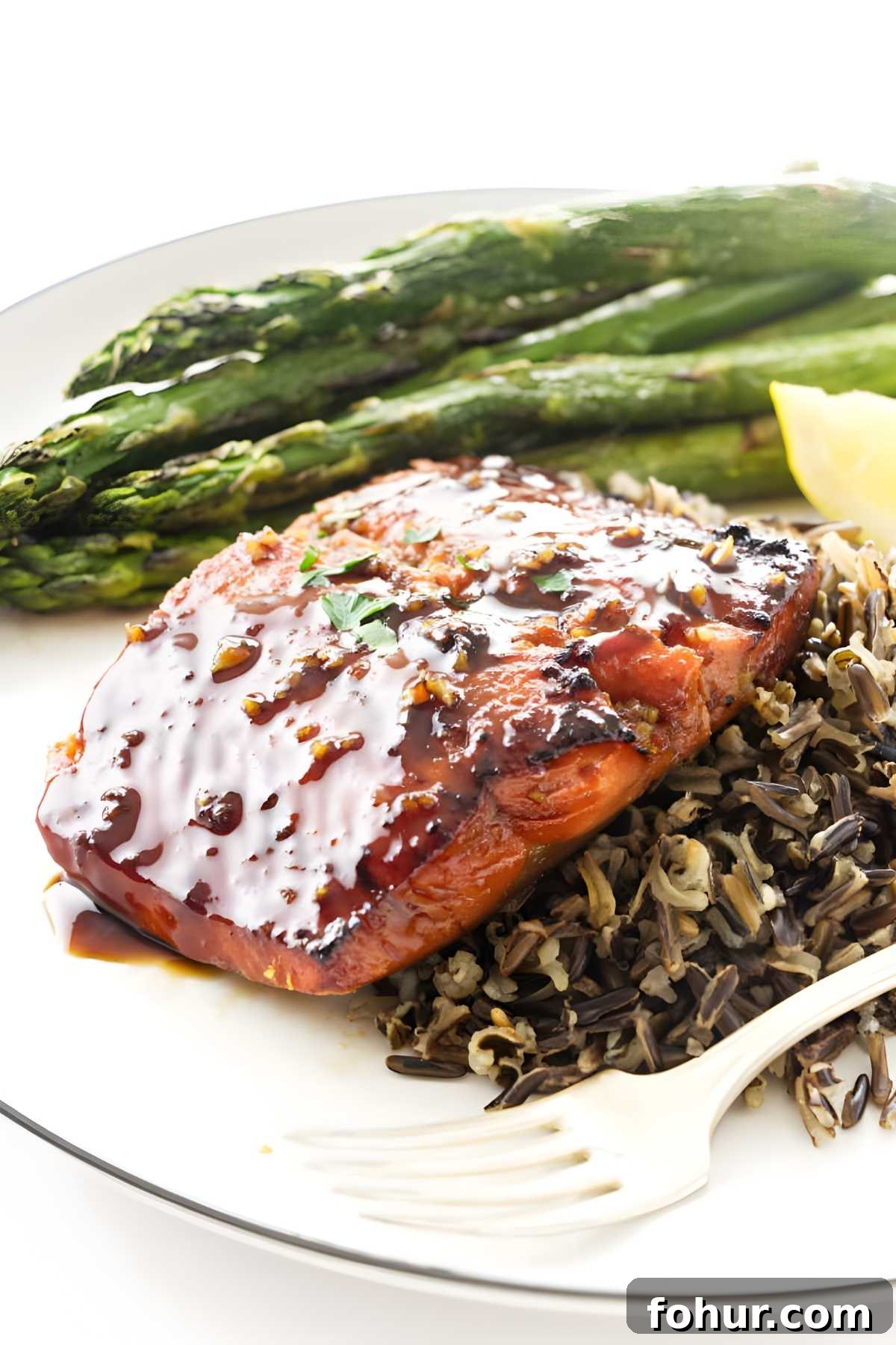 Bourbon Glazed Salmon Fillet Recipe 7 Grilled salmon with wild rice, roasted asparagus, and lemon wedge on plate.